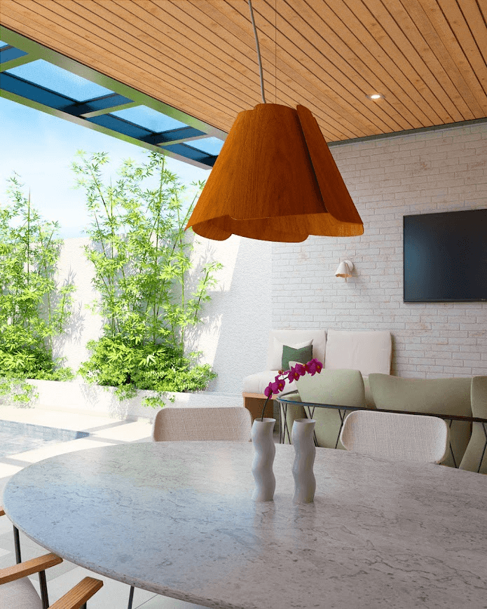 Mesa de jantar redonda junto à piscina, com pendente de madeira e sofá ao fundo