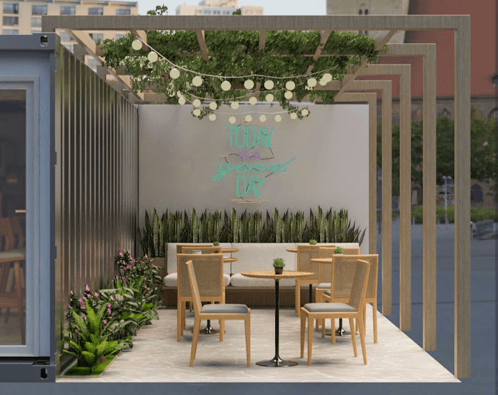 Área externa da cafeteria com pergolado de madeira, luzes e letreiro neon