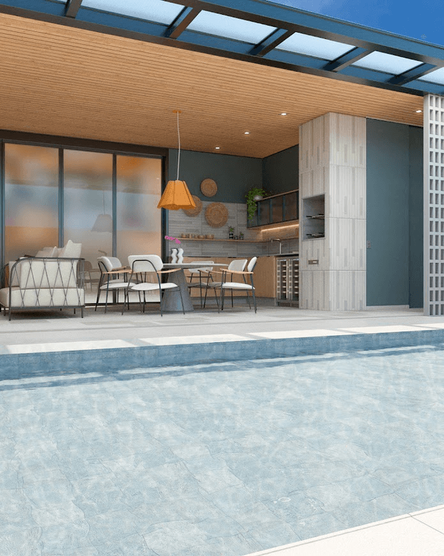 Área gourmet vista da piscina, com cozinha externa e mesa de jantar sob o pergolado